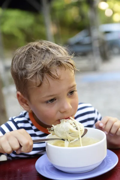 Menino comer sopa de frango — Fotografia de Stock