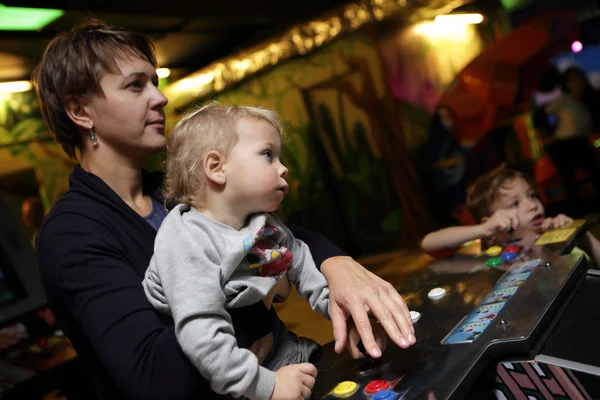 Family playing in the slot machines — Stock Photo, Image