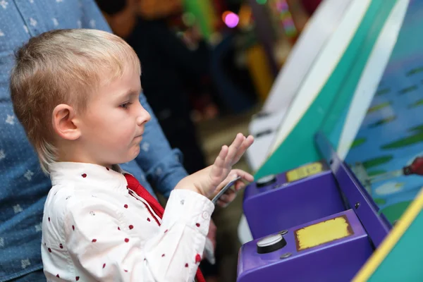 Child playing in the slot machines — Stock Photo, Image