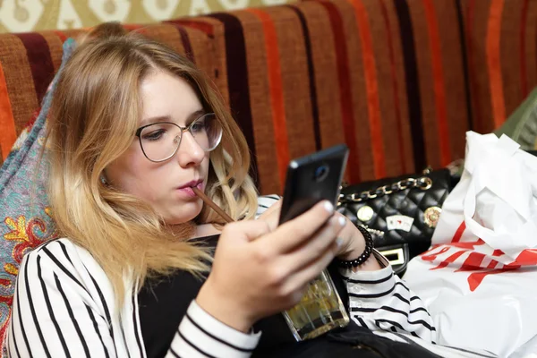 Tonåring dricka saft och tittar på smartphone — Stockfoto