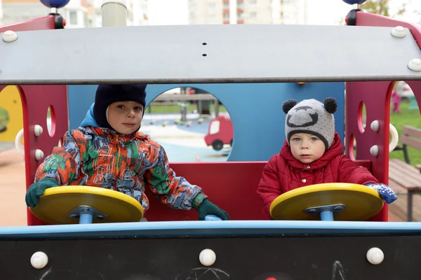 Dos hermanos conduciendo coche de juguete —  Fotos de Stock