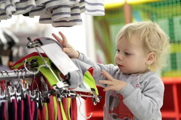 Serious toddler choosing clothes — Stock Photo, Image