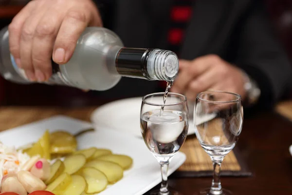 Person schenkt Wodka ein — Stockfoto