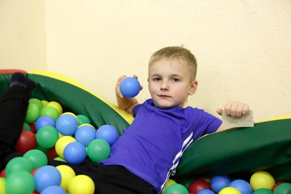 Kind spielt in Kiste mit Bällen — Stockfoto