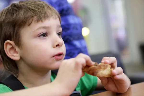 Мальчик ест пончик — стоковое фото