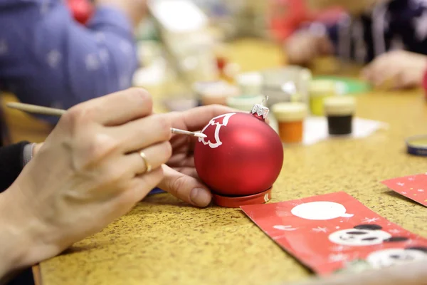 Persona pintando bola de Navidad — Foto de Stock