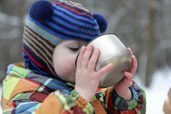 Criança bebendo chá no inverno — Fotografia de Stock