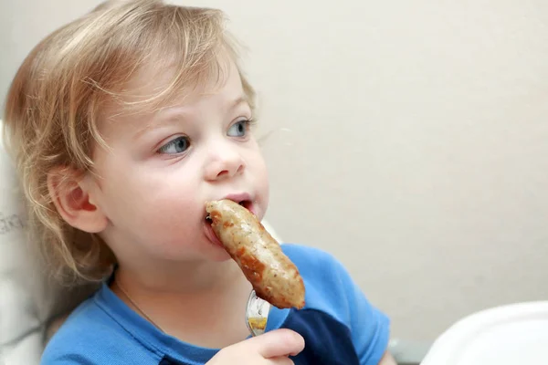 Criança comendo salsicha — Fotografia de Stock