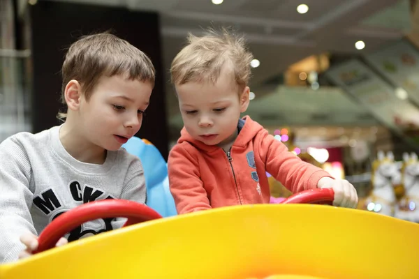 Irmãos condução brinquedo carro — Fotografia de Stock