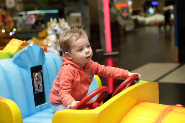 Мальчик за рулем игрушечной машины — стоковое фото