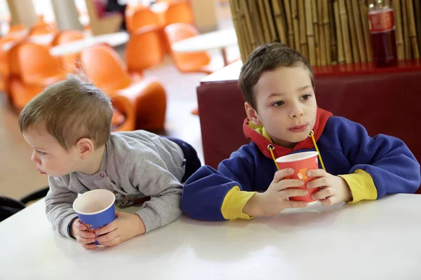 Duas crianças bebendo suco — Fotografia de Stock