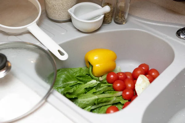 Моющиеся овощи в раковине — стоковое фото