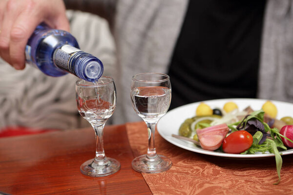 Лицо, наливающее водку
