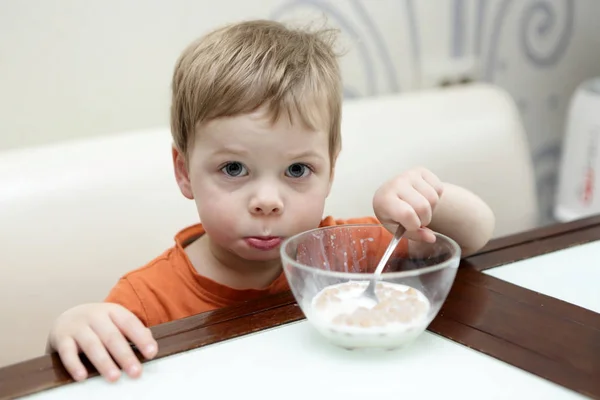 Criança comendo flocos no leite — Fotografia de Stock