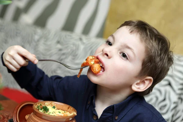 Menino comer legumes assados — Fotografia de Stock