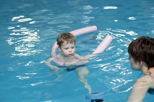 Mor och hennes son i poolen — Stockfoto