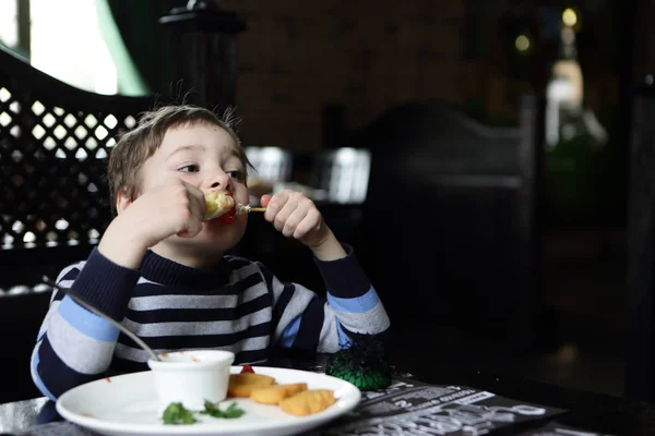 Мальчик ест кебаб — стоковое фото