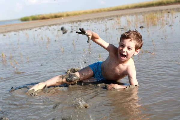 Мальчик лежит в лечебной грязи — стоковое фото