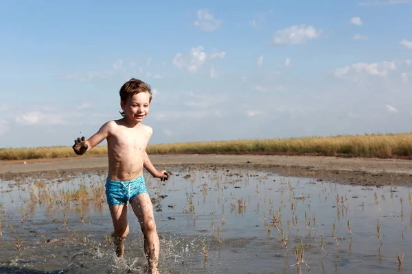 Kid körs i helande lera — Stockfoto