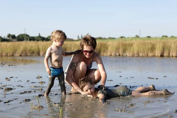 Moeder met twee zoons in genezende modder — Stockfoto