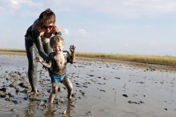 Mulher e criança na lama de cura — Fotografia de Stock
