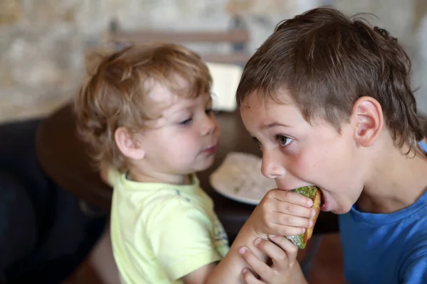 Brothers eating eclair — Stock Photo, Image