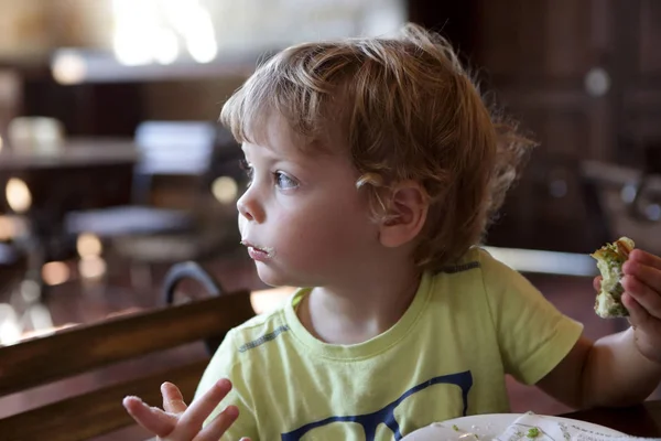 Menino comendo eclair — Fotografia de Stock