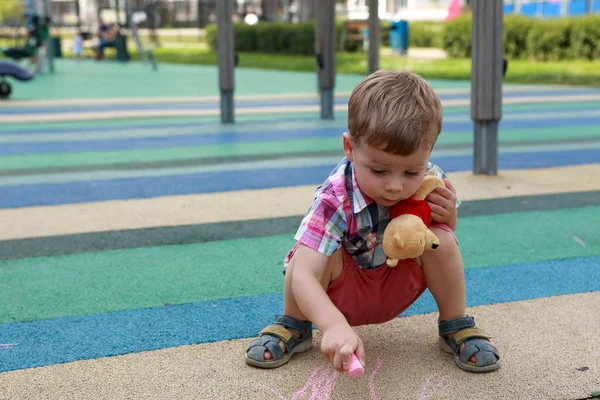 Kind zeichnet auf Spielplatz — Stockfoto