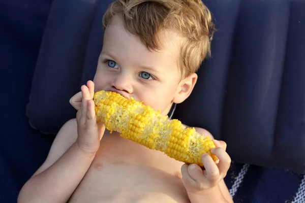 Niño comiendo maíz — Foto de Stock