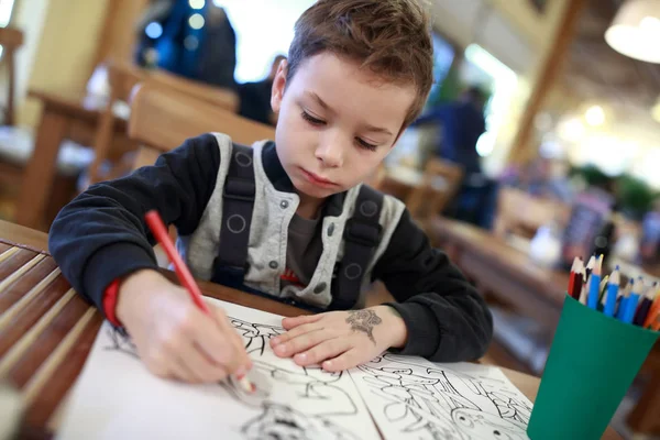 Jongen tekening in café — Stockfoto