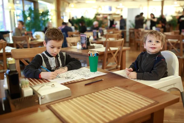 Dois irmãos desenhando no restaurante — Fotografia de Stock