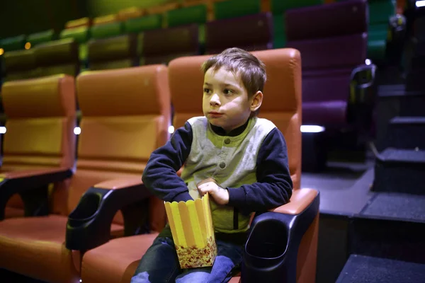 Criança comendo pipoca no cinema — Fotografia de Stock