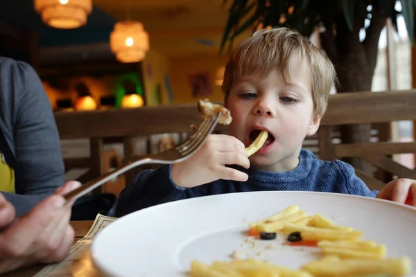 Ребенок ест картошку фри — стоковое фото