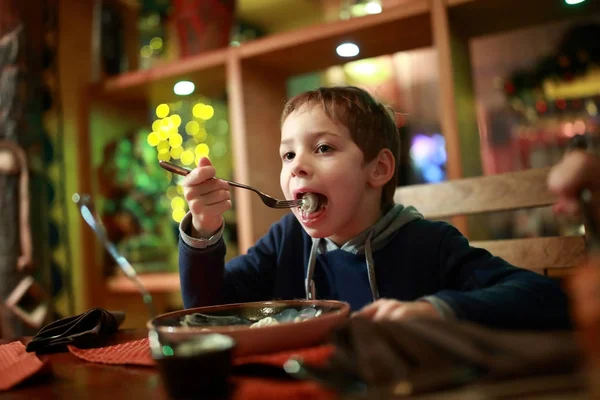 Niño comiendo pelmeni — Foto de Stock