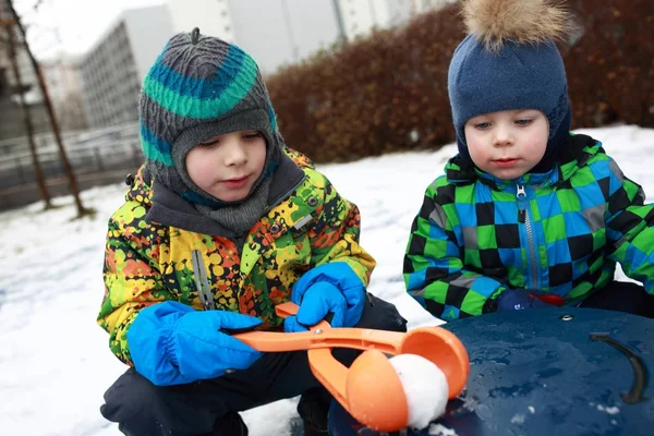 Αδελφοί, παίζοντας με το χιονιά maker — Φωτογραφία Αρχείου