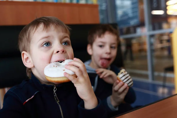 Niños comiendo rosquillas — Foto de Stock