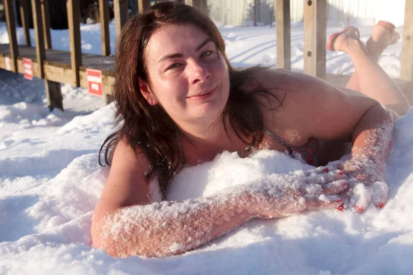 Femme souriante couchée dans la neige — Photo