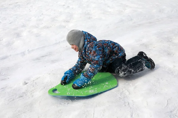 男孩骑雪橇下来 — 图库照片