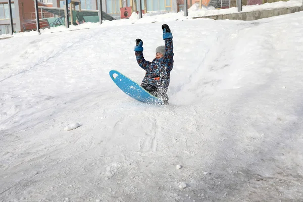Criança deslizando para baixo colina de neve — Fotografia de Stock