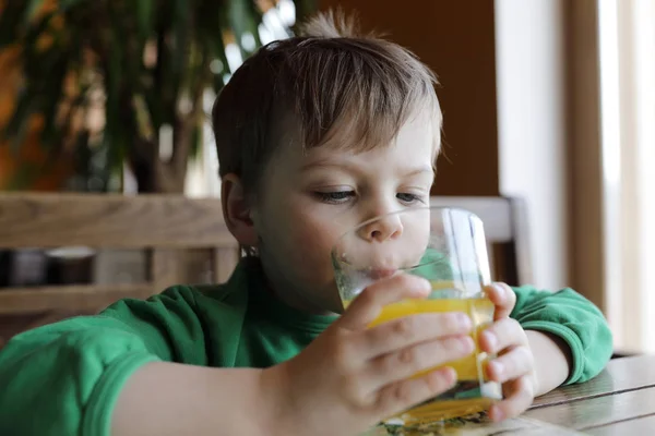 Ragazzo che beve succo d'arancia — Foto Stock