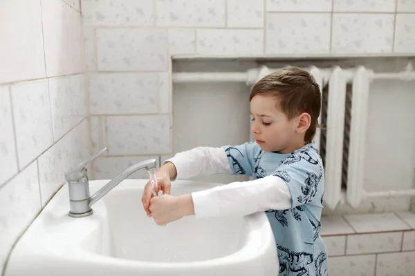 O miúdo lava as mãos. — Fotografia de Stock