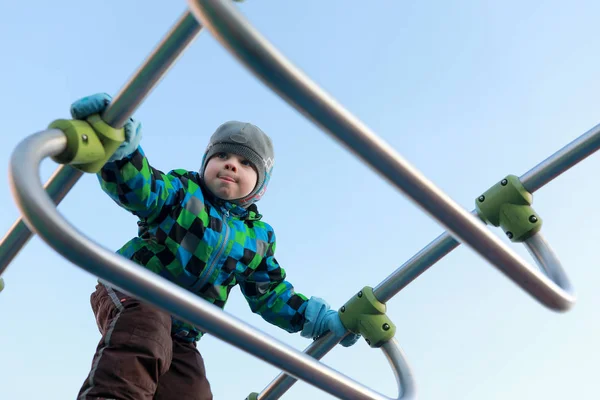 Niño escalando puente de metal — Foto de Stock