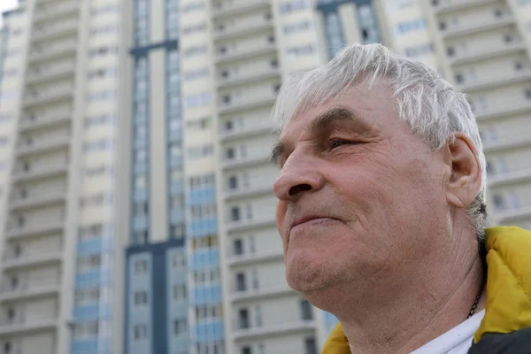 Hombre mayor en el nuevo fondo del edificio —  Fotos de Stock