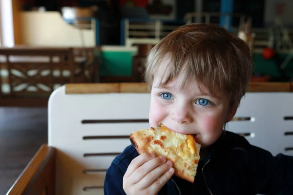 Bambino che morde pizza — Foto Stock