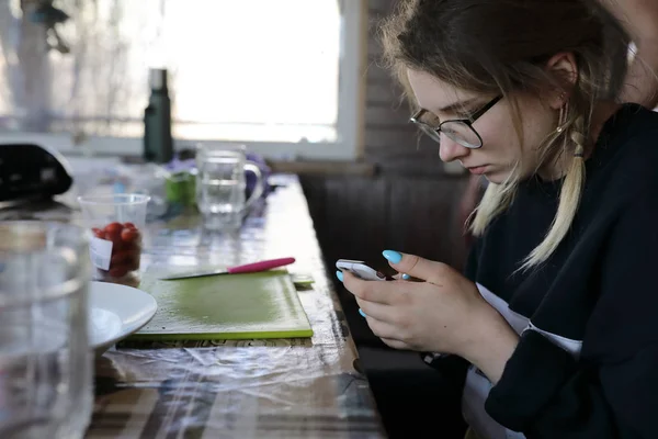 Teen with smartphone in kitchen — Stock Photo, Image