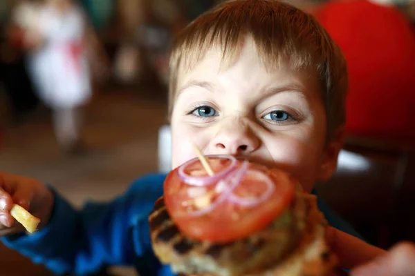 Niño comiendo hamburguesa — Foto de Stock