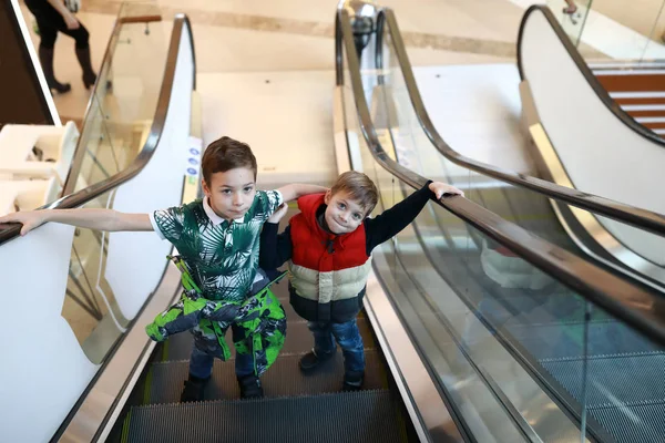 Children ride up escalator — Stock Photo, Image