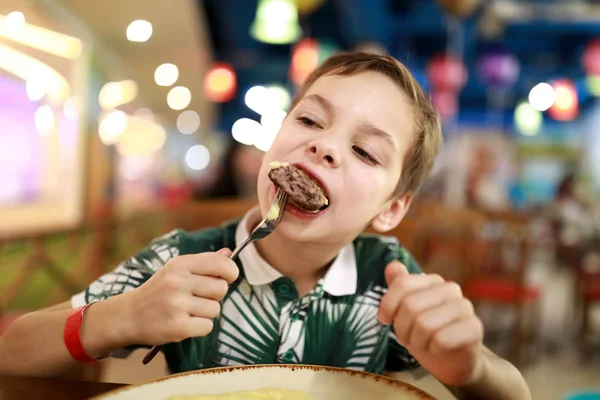 Niño comiendo chuleta de ternera — Foto de Stock