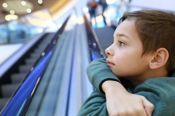 Niño de pie en escaleras mecánicas — Foto de Stock