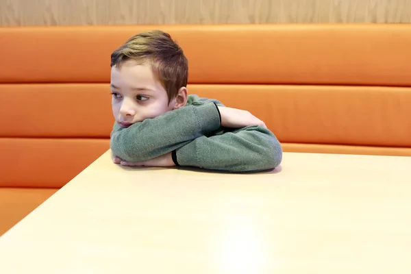 Pensive kid in restaurant — Stock Photo, Image